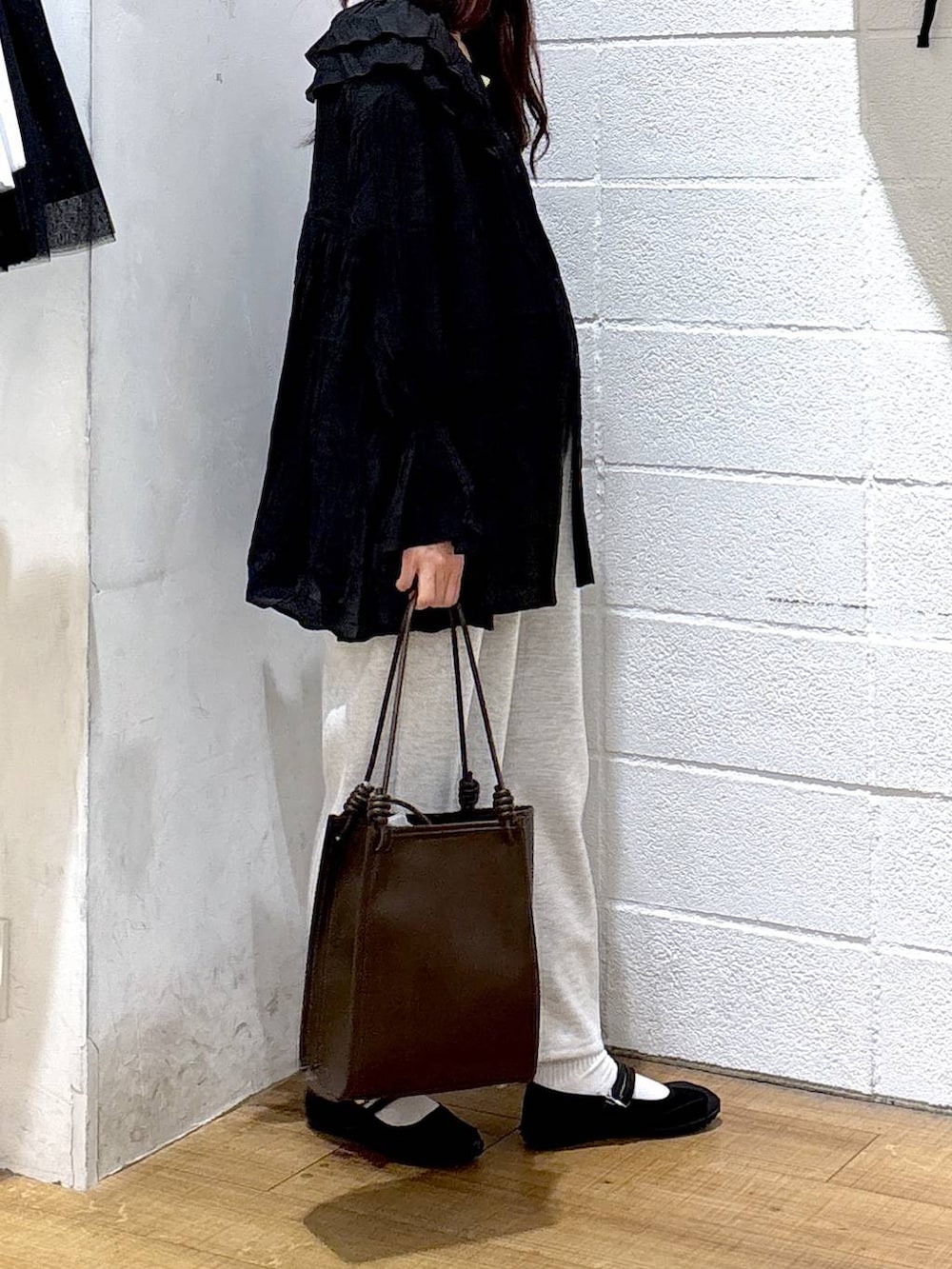 グレー系のスウェットパンツ、ブラック系のスニーカー、ホワイト系のタンクトップを着用したレディースの春コーディネートの2枚目の写真