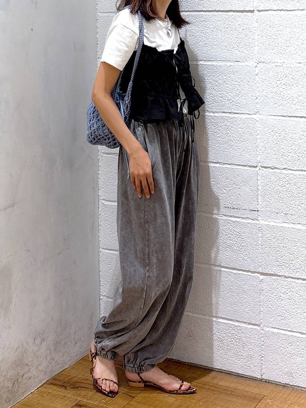 ブルー系のトートバッグ、ホワイト系のTシャツ/カットソー、ブラック系のキャミソールを着用したレディースの夏コーディネートの2枚目の写真