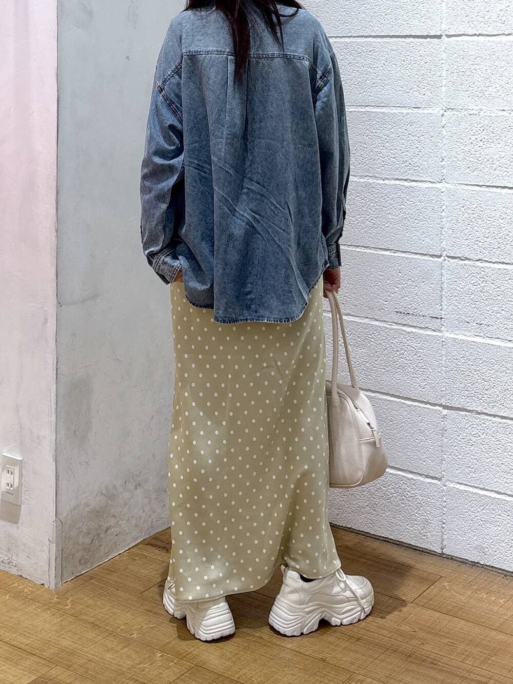 ベージュ系のスカート、ブルー系のシャツ/ブラウス、ホワイト系のボストンバッグを着用したレディースの冬コーディネートの3枚目の写真