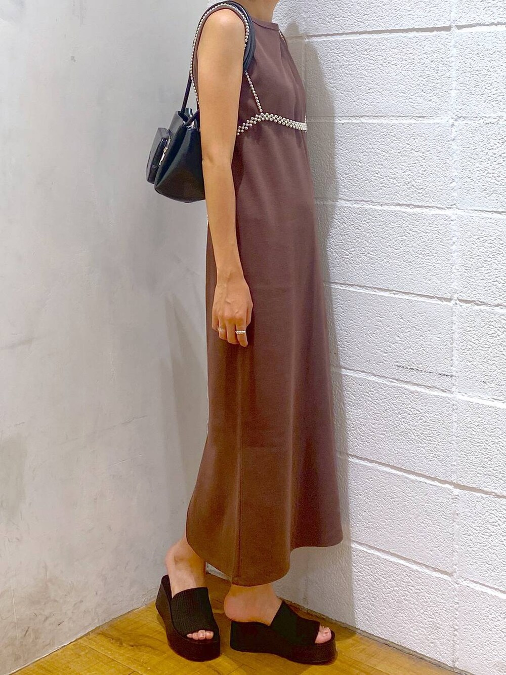 ブラック系のサンダル、ブラウン系のワンピース、ブラック系のショルダーバッグを着用したレディースの夏コーディネートの2枚目の写真