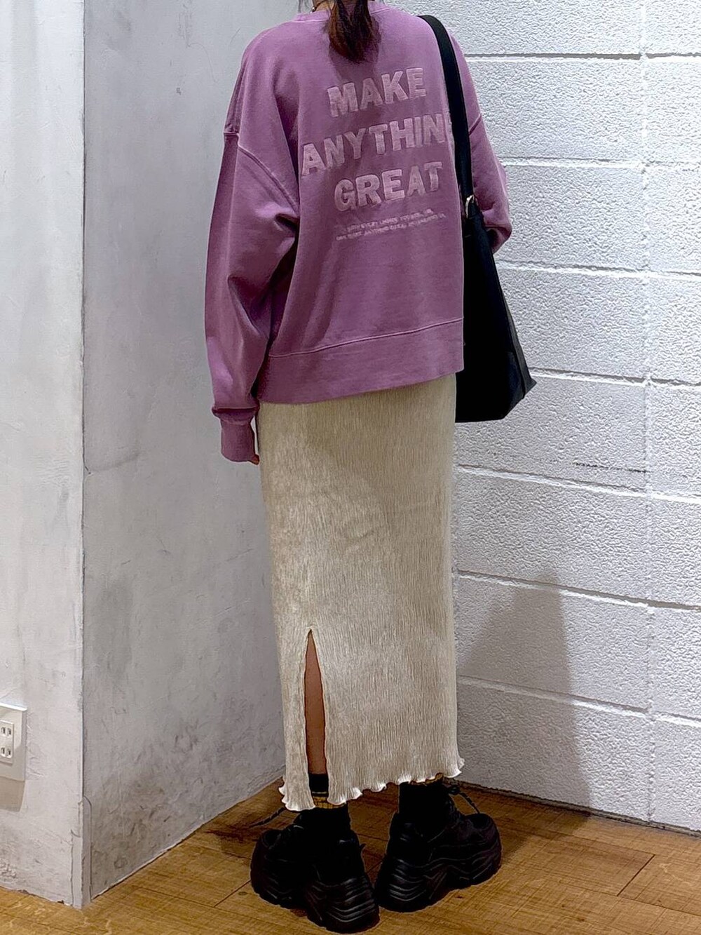 ブラック系のショルダーバッグ、パープル系のスウェット、ホワイト系のスカートを着用したレディースの秋コーディネートの3枚目の写真