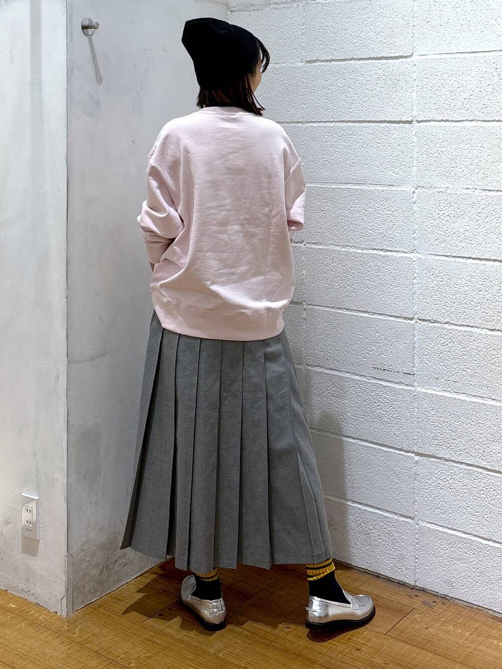 シルバー系のローファー、グレー系のスカート、ピンク系のスウェットを着用したレディースの冬コーディネートの3枚目の写真