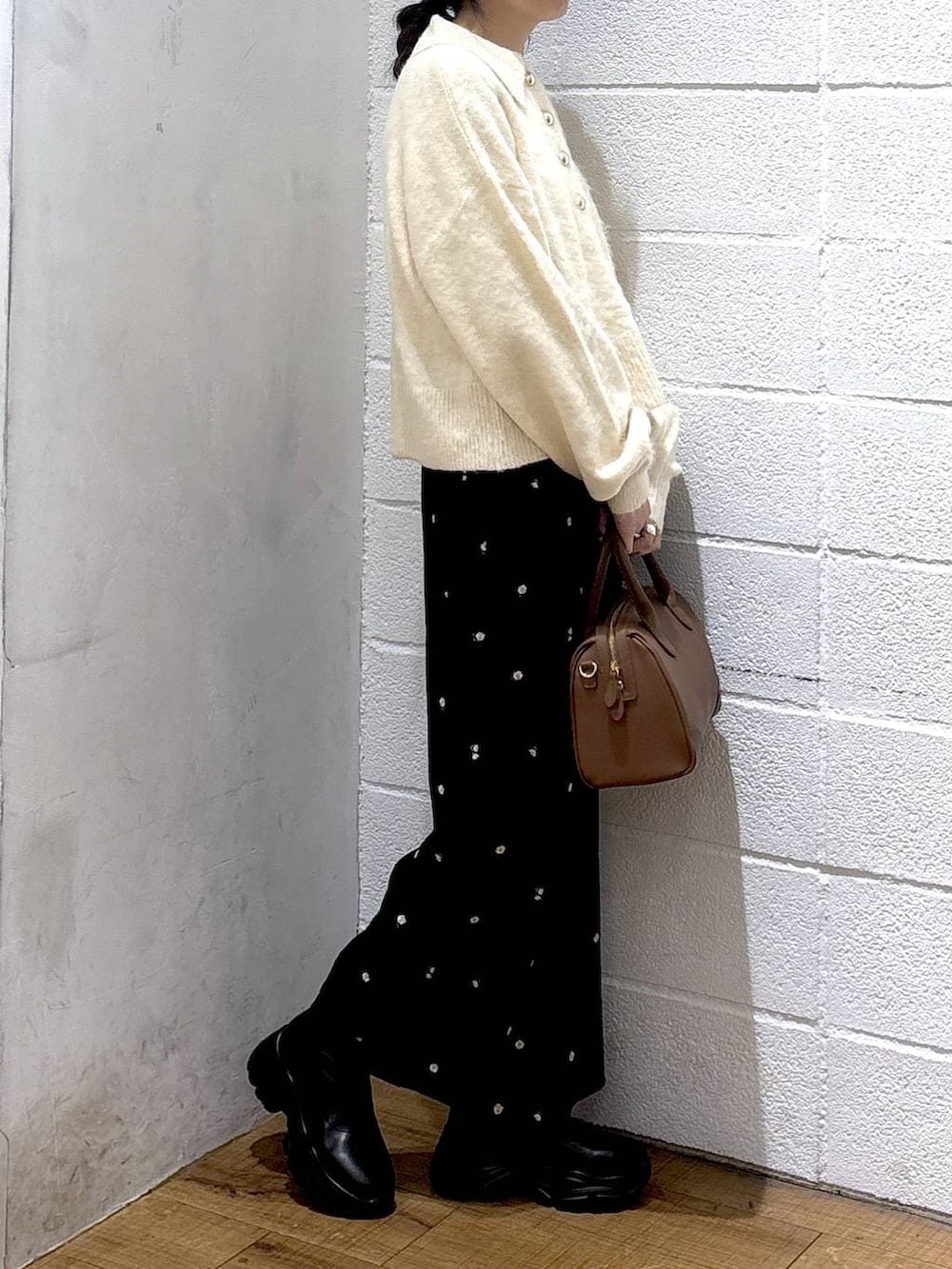 ブラック系のブーツ、ブラウン系のショルダーバッグ、ホワイト系のニット/セーターを着用したレディースの冬コーディネートの2枚目の写真
