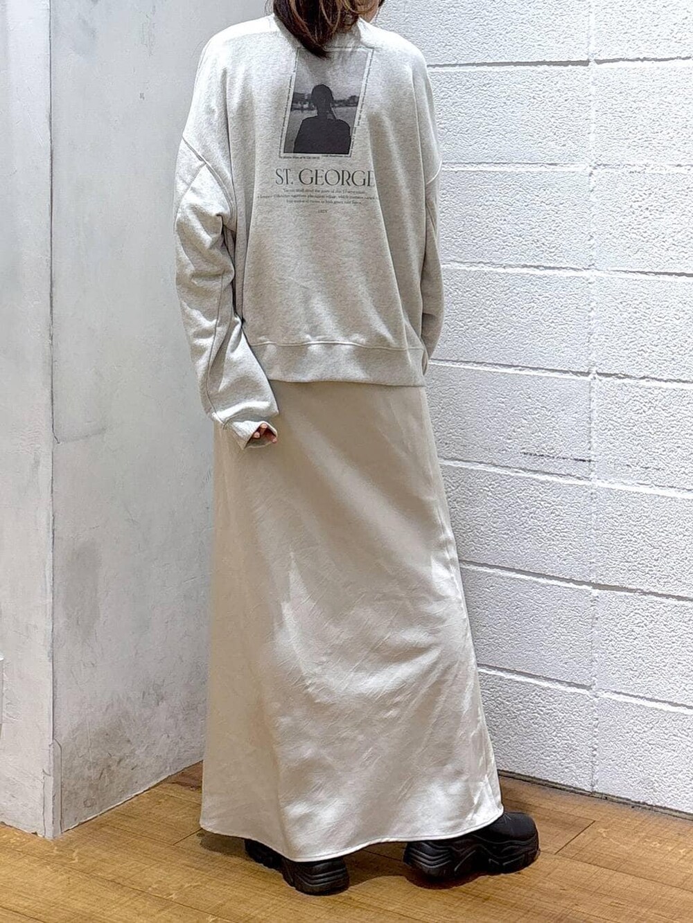 ブラック系のブーツ、ホワイト系のスカート、イエロー系のニット/セーターを着用したレディースの冬コーディネートの3枚目の写真