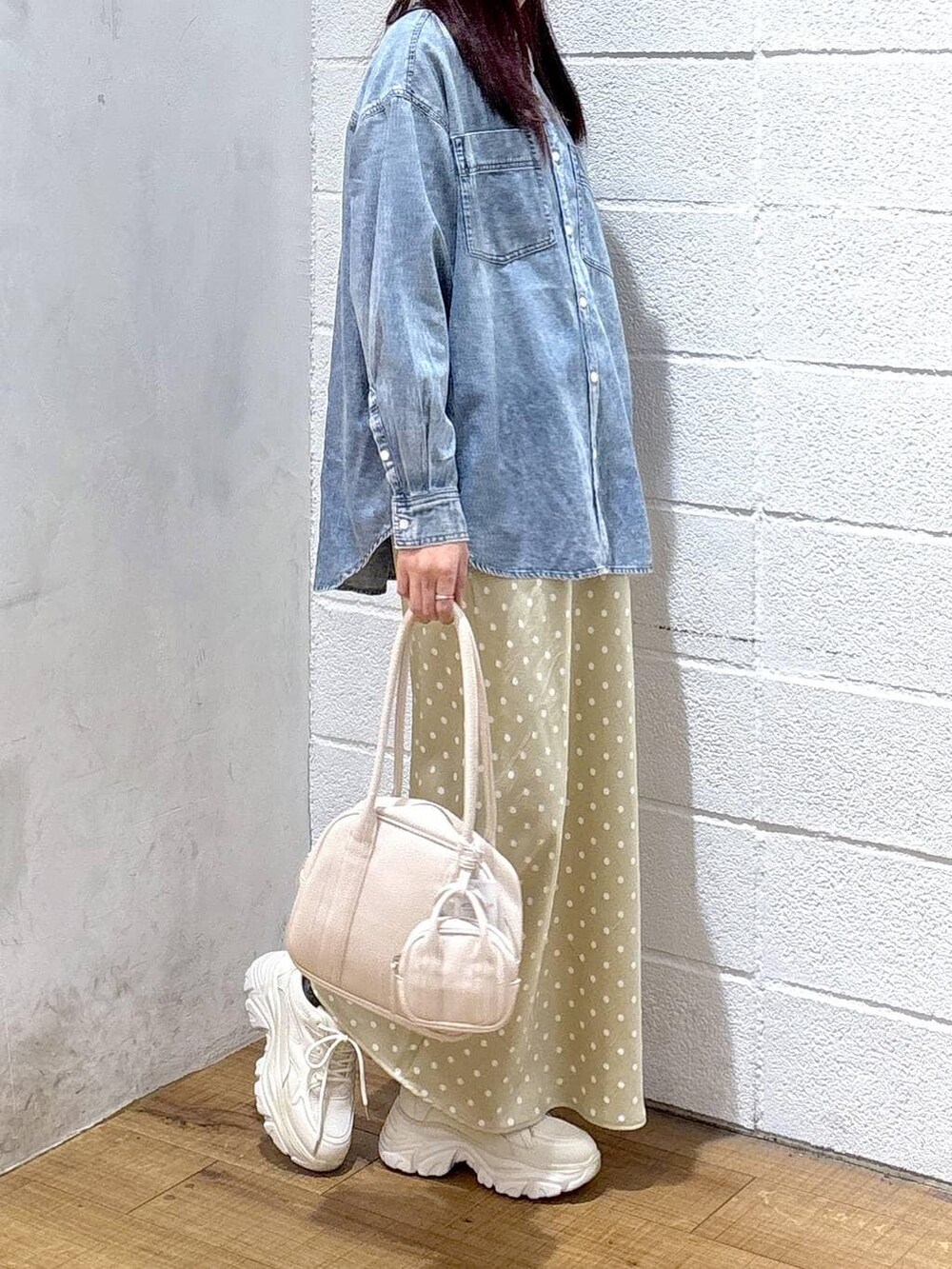 ベージュ系のスカート、ブルー系のシャツ/ブラウス、ホワイト系のボストンバッグを着用したレディースの冬コーディネートの2枚目の写真