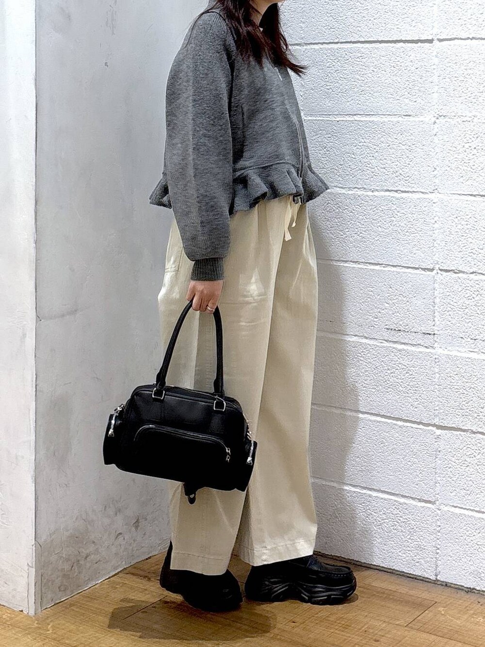 ホワイト系のデニムパンツ、ブラック系のボストンバッグ、ブラック系のローファーを着用したレディースの冬コーディネートの2枚目の写真