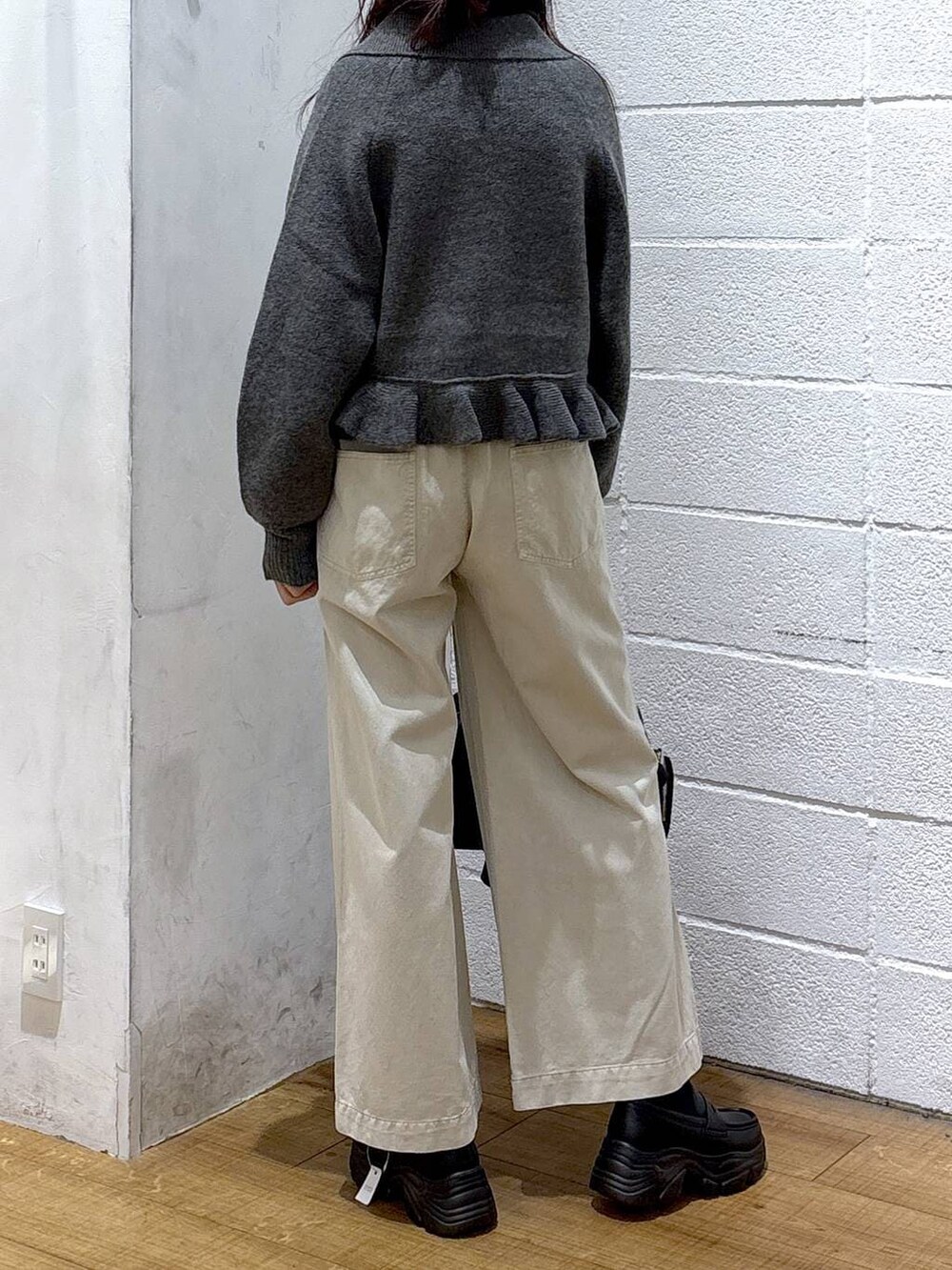 ホワイト系のデニムパンツ、ブラック系のボストンバッグ、ブラック系のローファーを着用したレディースの冬コーディネートの3枚目の写真