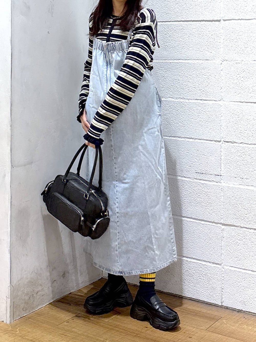 ブラック系のボストンバッグ、ブラック系のローファー、ブルー系のワンピースを着用したレディースの冬コーディネートの2枚目の写真