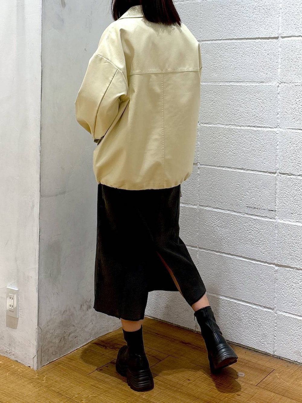 ブラック系のブーツ、ブラック系のショルダーバッグ、ホワイト系のブルゾンを着用したレディースの冬コーディネートの3枚目の写真