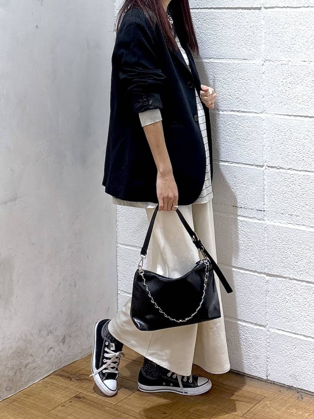 ホワイト系のスカート、ブラック系のテーラードジャケット、ブラック系のショルダーバッグを着用したレディースの冬コーディネートの2枚目の写真