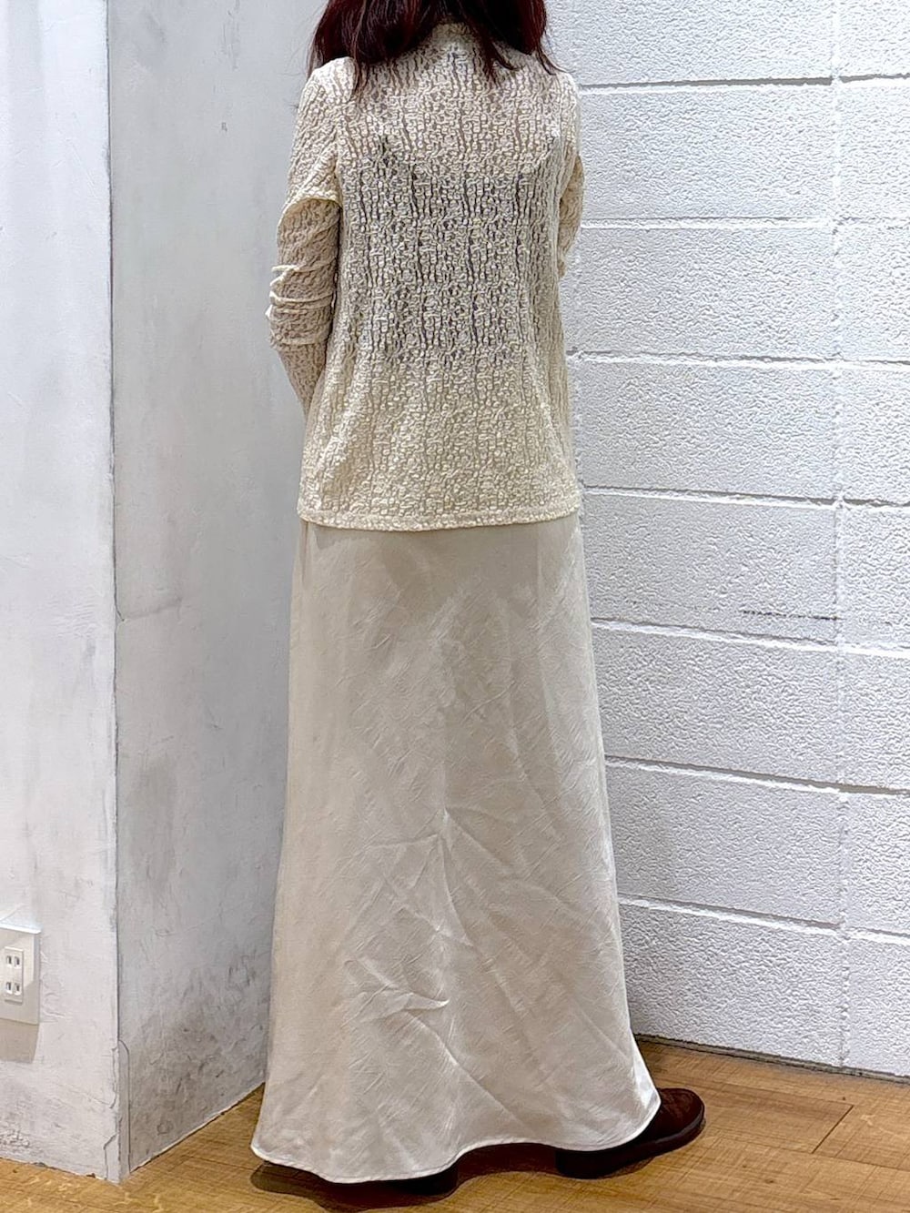 ホワイト系のスカート、ブラウン系のスニーカー、ブラック系のボストンバッグを着用したレディースの秋コーディネートの3枚目の写真