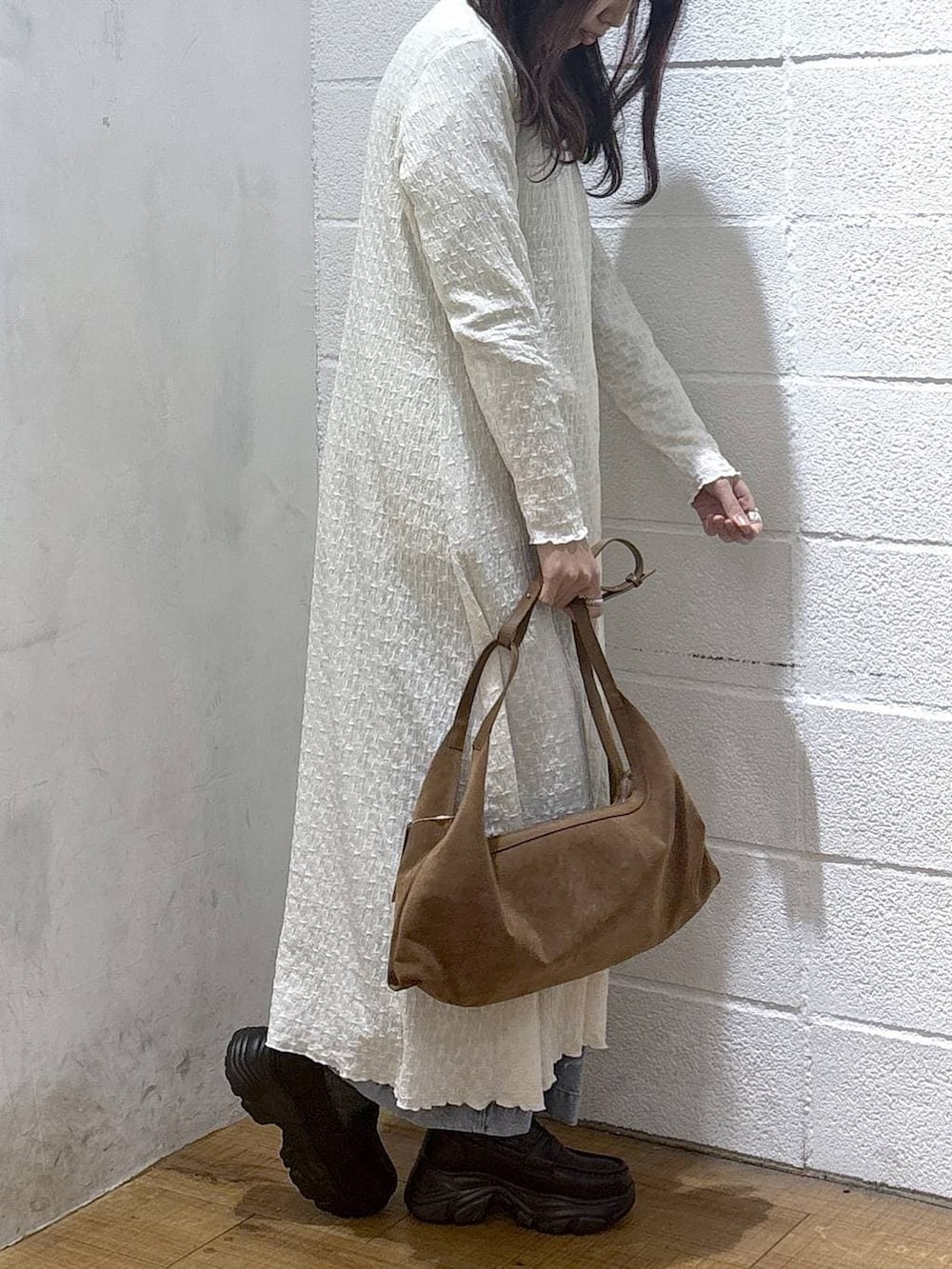 ブルー系のデニムパンツ、ブラック系のローファー、ブラウン系のショルダーバッグを着用したレディースの冬コーディネートの2枚目の写真