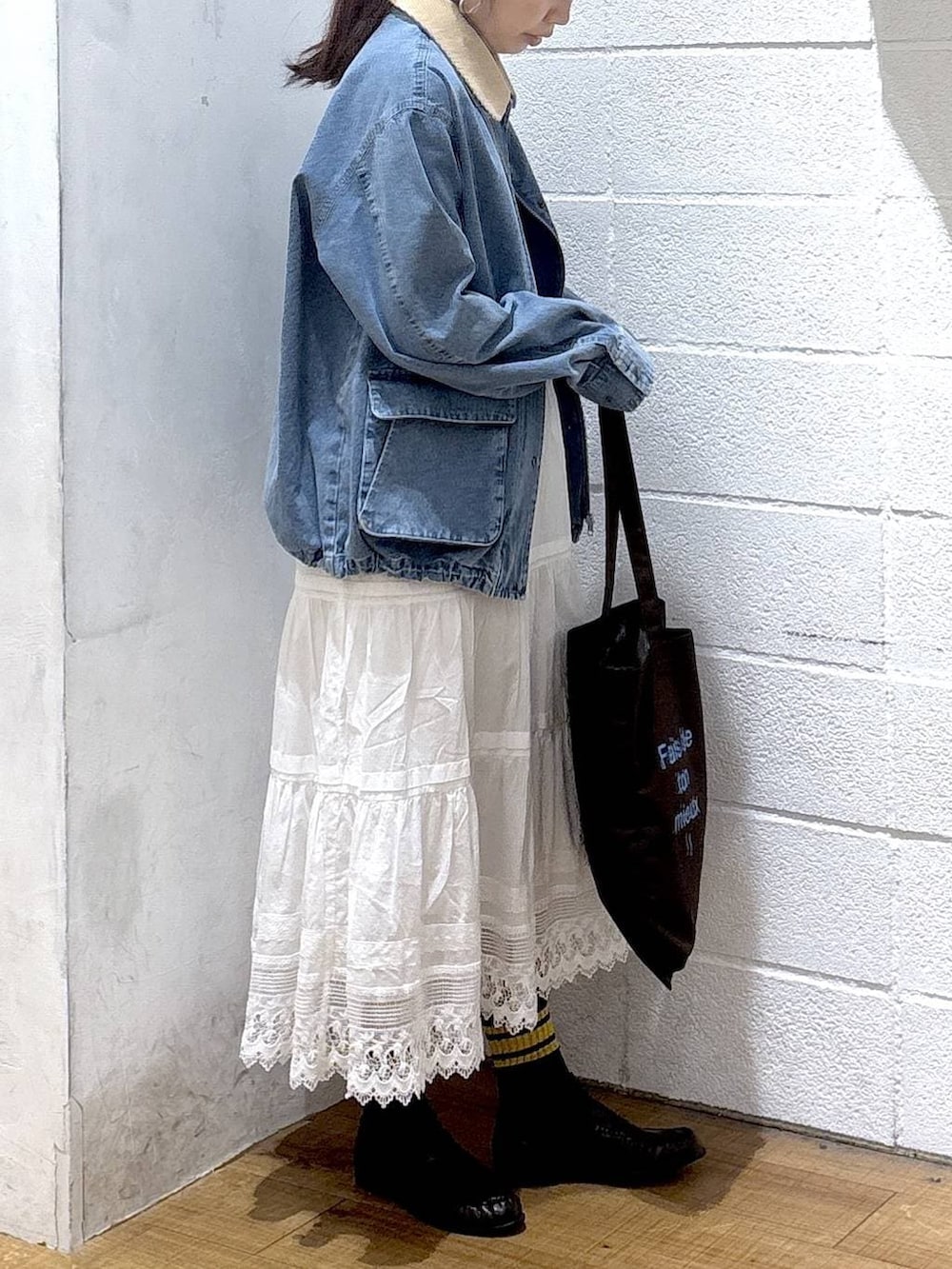 ブラウン系のトートバッグ、ブルー系のその他アウター、ブラウン系のローファーを着用したレディースの春コーディネートの3枚目の写真