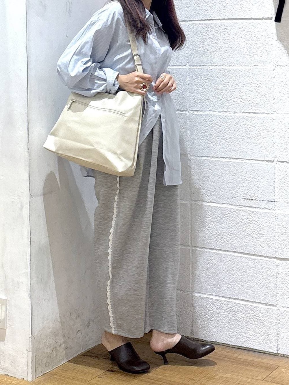 ホワイト系のショルダーバッグ、グレー系のスウェットパンツ、ブルー系のシャツ/ブラウスを着用したレディースの春コーディネートの2枚目の写真