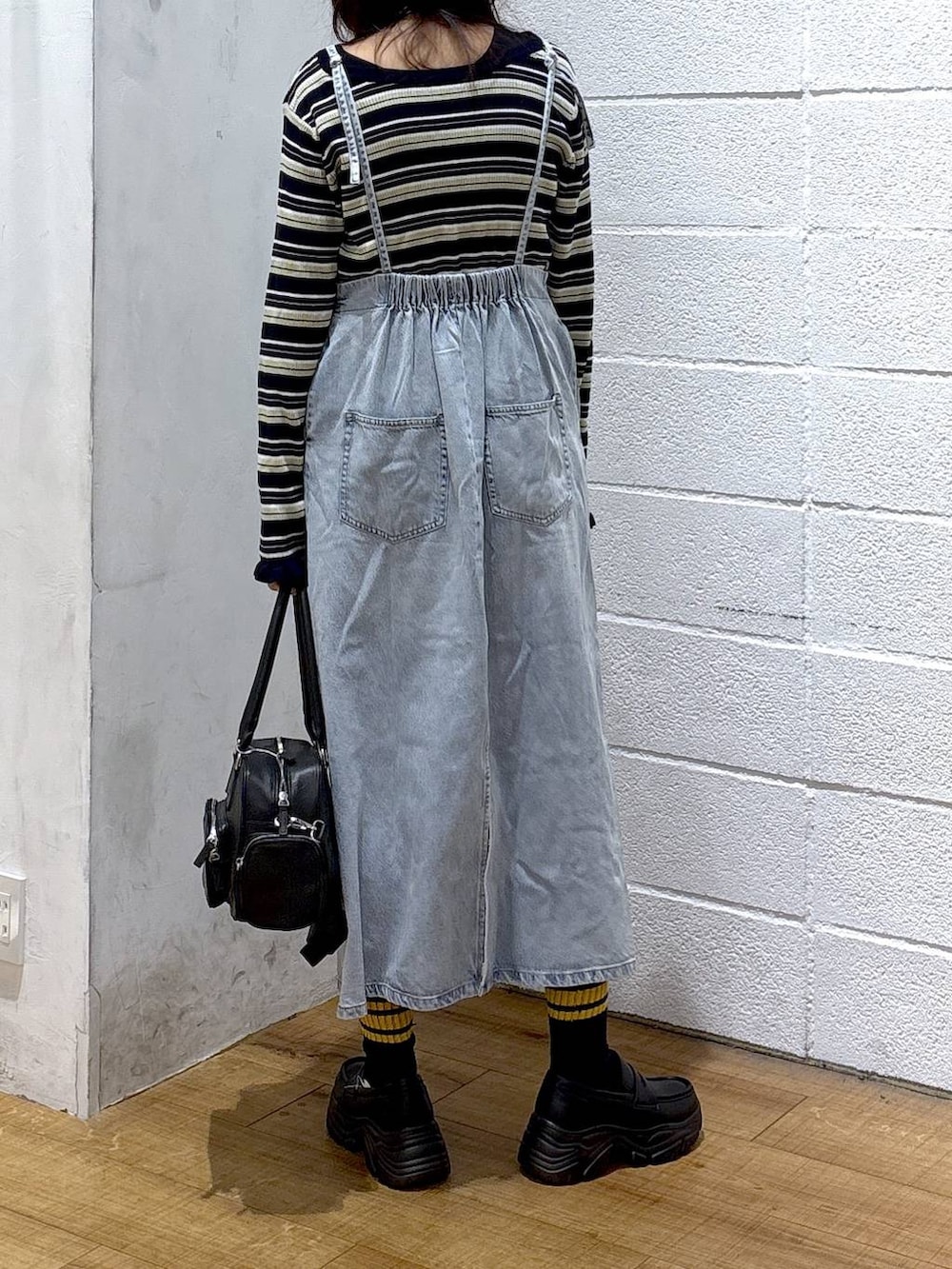 ブラック系のボストンバッグ、ブラック系のローファー、ブルー系のワンピースを着用したレディースの冬コーディネートの3枚目の写真