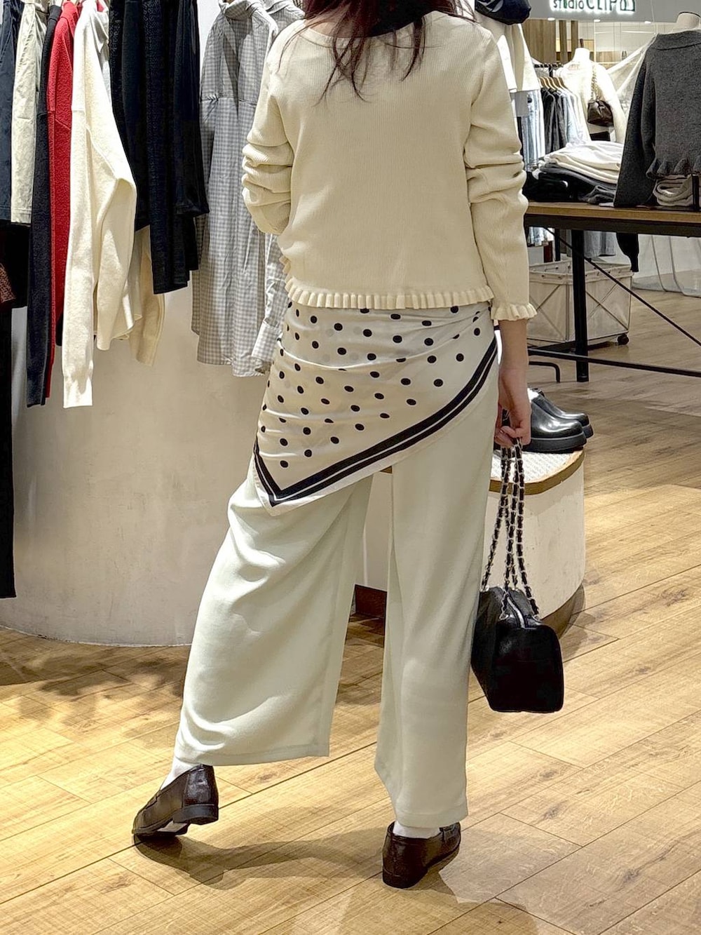 ブラック系のショルダーバッグ、ブラウン系のローファー、グリーン系のその他パンツを着用したレディースの冬コーディネートの3枚目の写真