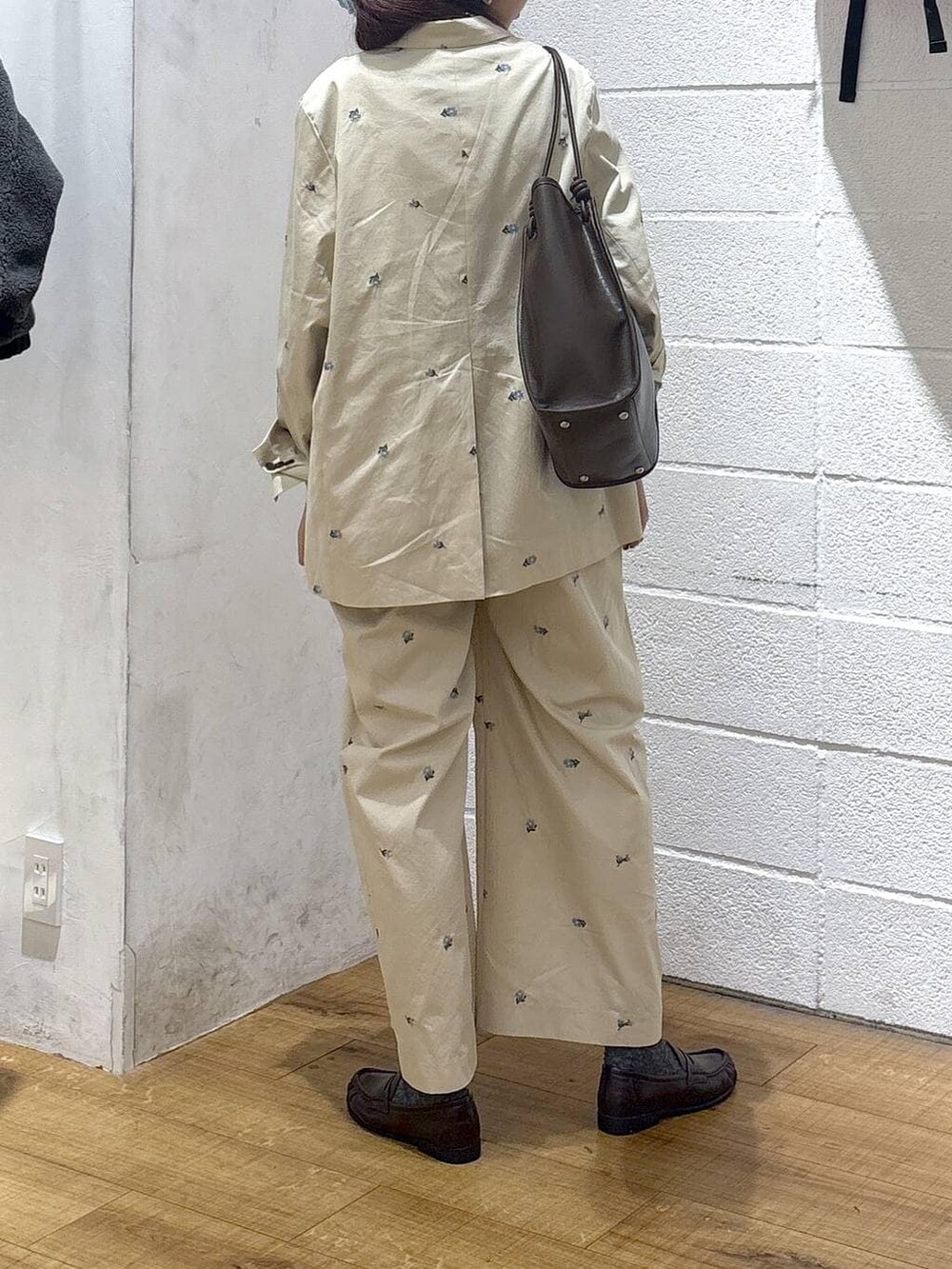 ホワイト系のタンクトップ、ブラウン系のトートバッグ、ベージュ系のその他アウターを着用したレディースの春コーディネートの3枚目の写真