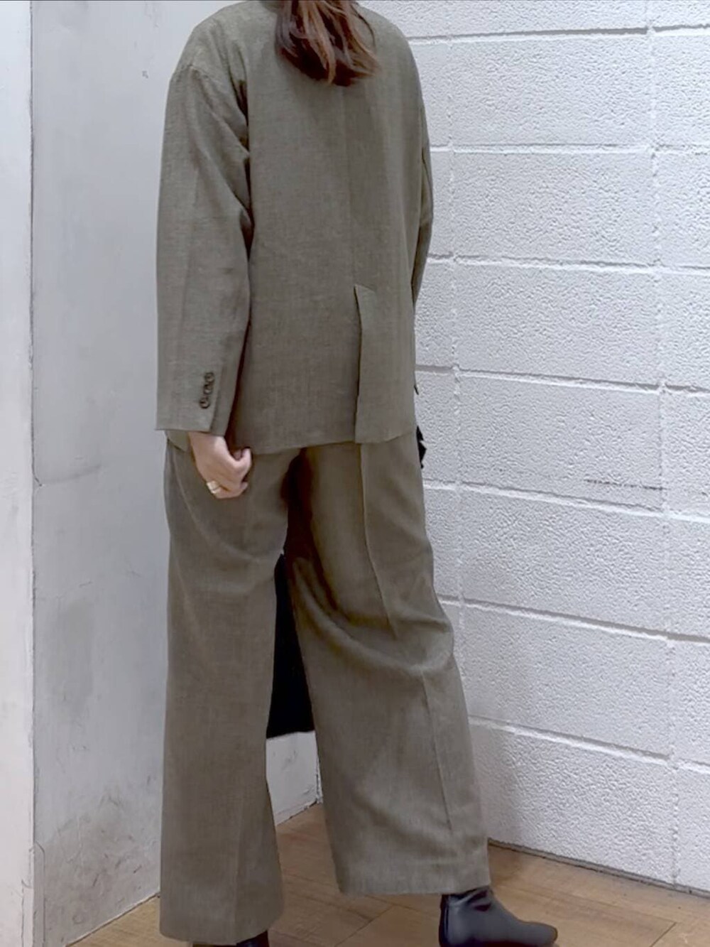 ブラック系のニット/セーター、ブラウン系のテーラードジャケット、ブラウン系のデニムパンツを着用したレディースの冬コーディネートの3枚目の写真