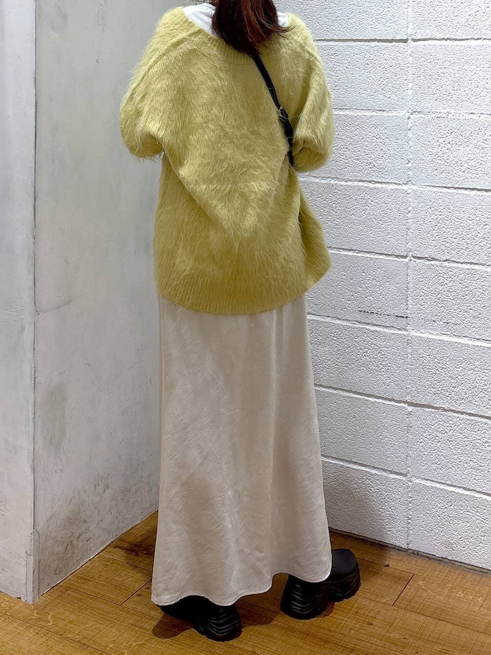 ブラック系のブーツ、ホワイト系のスカート、その他のボストンバッグを着用したレディースの秋コーディネートの2枚目の写真