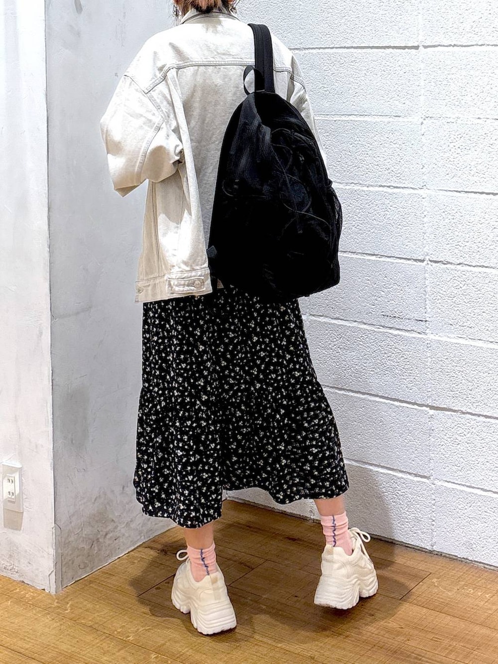 グレー系のデニムジャケット、ホワイト系のスニーカー、グレー系のバックパック/リュックを着用したレディースの春コーディネートの3枚目の写真