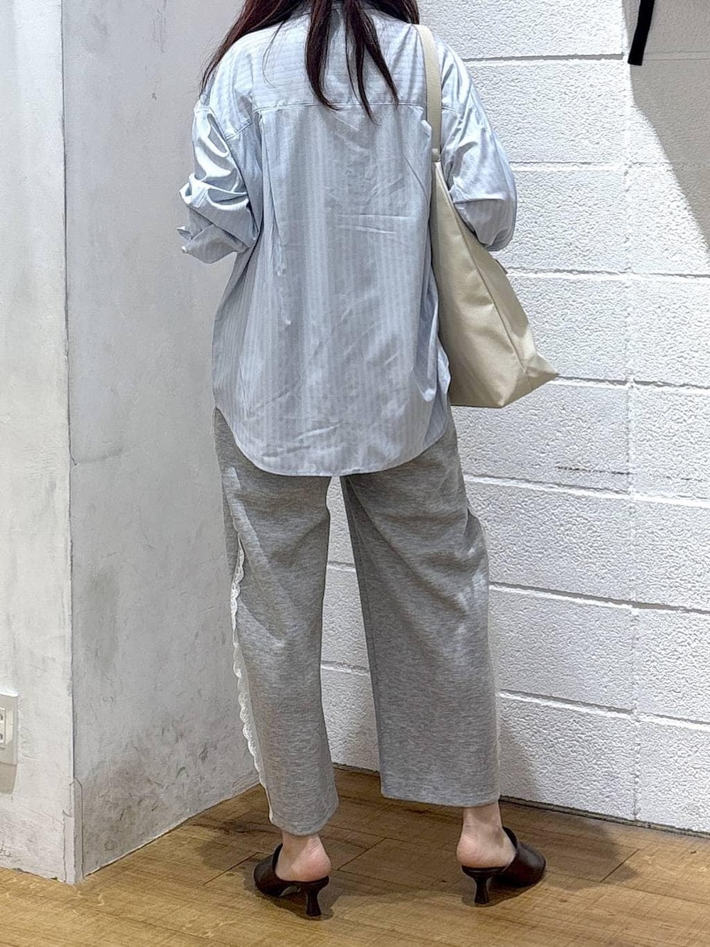 ホワイト系のショルダーバッグ、グレー系のスウェットパンツ、ブルー系のシャツ/ブラウスを着用したレディースの春コーディネートの3枚目の写真