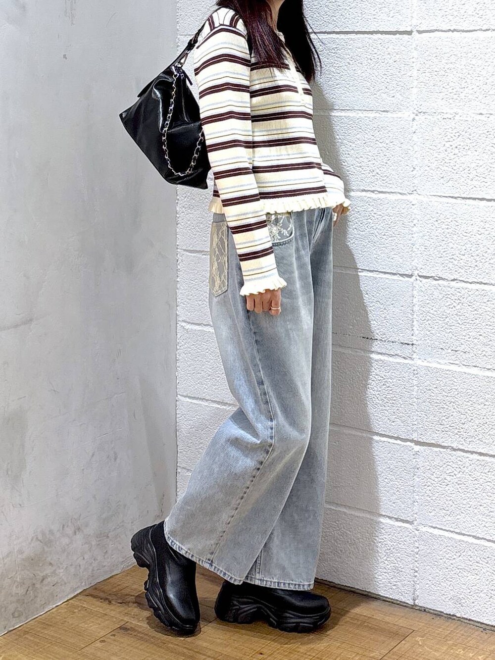 ブルー系のデニムパンツ、ホワイト系のニット/セーターを着用したレディースの冬コーディネートの2枚目の写真