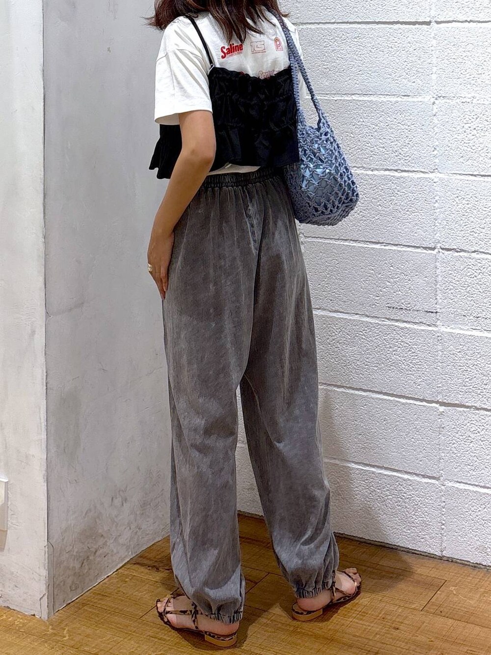 ブルー系のトートバッグ、ホワイト系のTシャツ/カットソー、ブラック系のキャミソールを着用したレディースの夏コーディネートの3枚目の写真