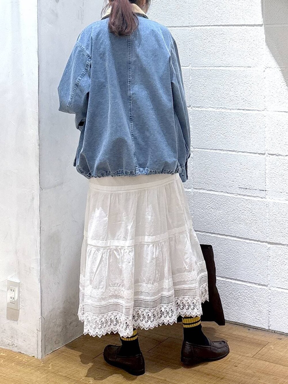 ブラウン系のトートバッグ、ブルー系のその他アウター、ブラウン系のローファーを着用したレディースの春コーディネートの2枚目の写真