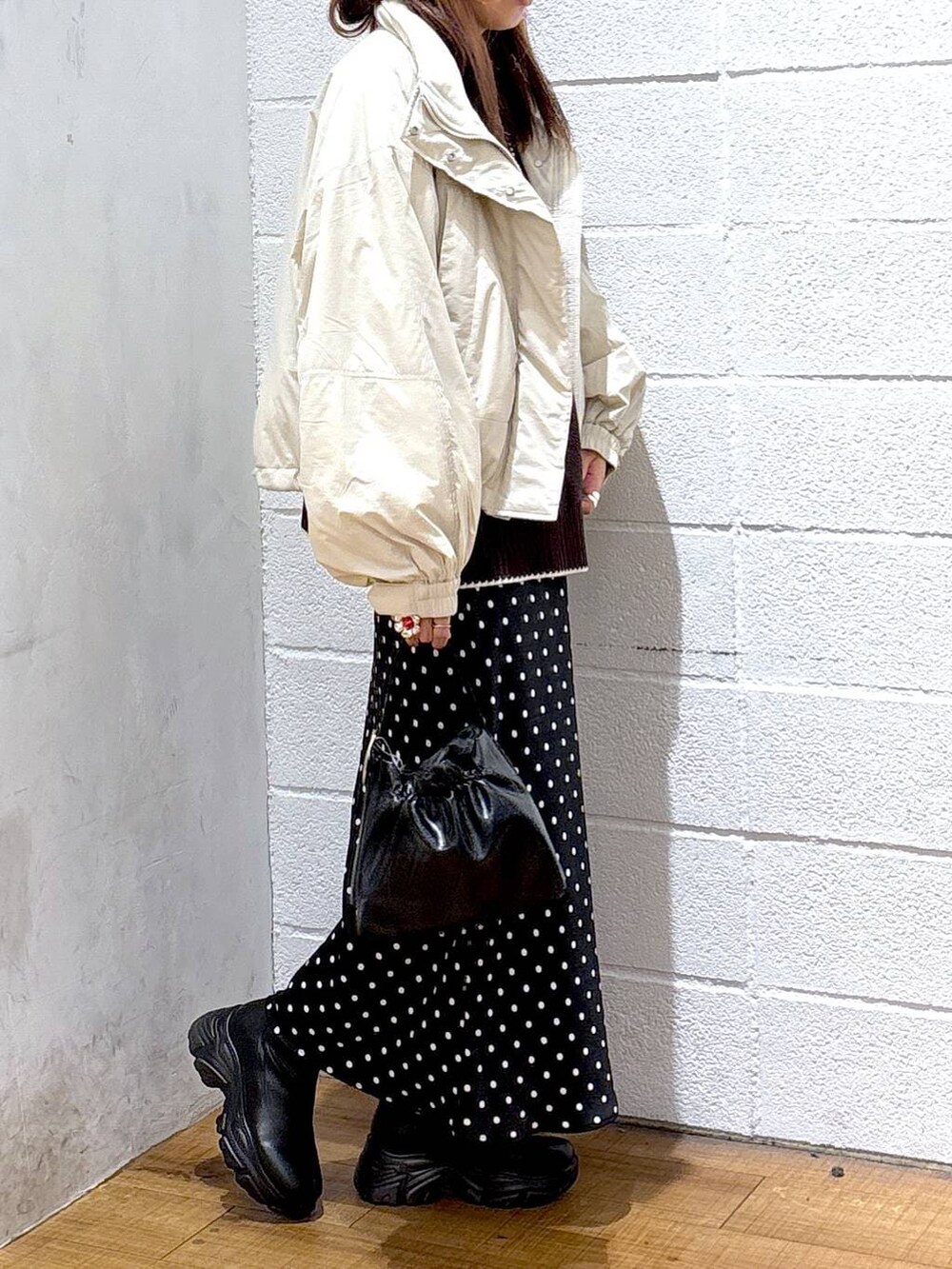 ホワイト系のその他アウター、ブラック系のブーツ、ブラック系のスカートを着用したレディースの秋コーディネートの2枚目の写真