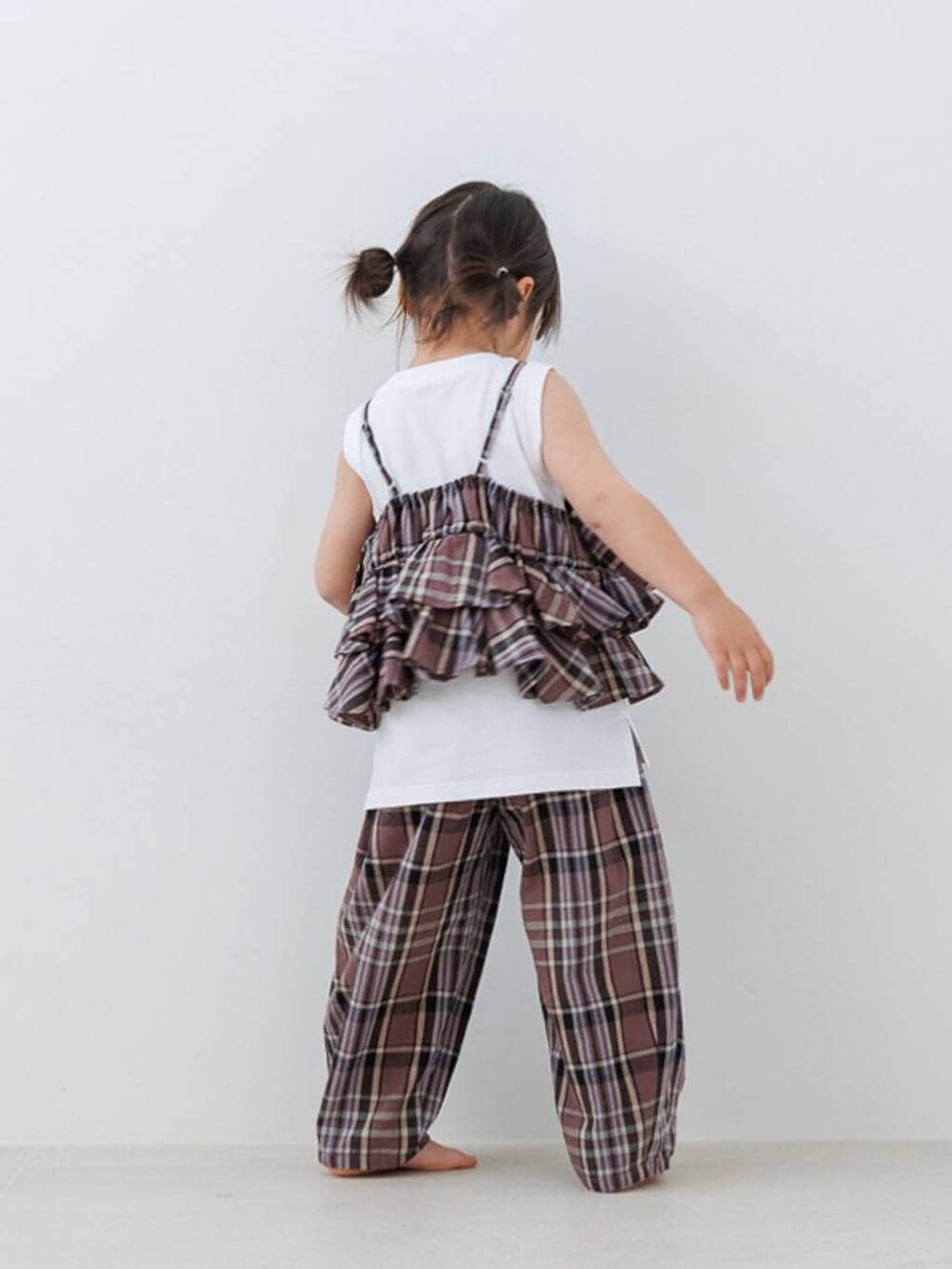 ホワイト系のタンクトップ、ブラウン系のキャミソール、ブラウン系のその他パンツを着用したキッズの春コーディネートの2枚目の写真