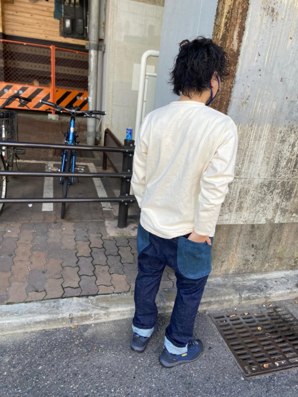 ホワイト系のTシャツ/カットソー、ブルー系のデニムパンツ、グリーン系のスニーカーを着用したメンズの秋コーディネートの2枚目の写真