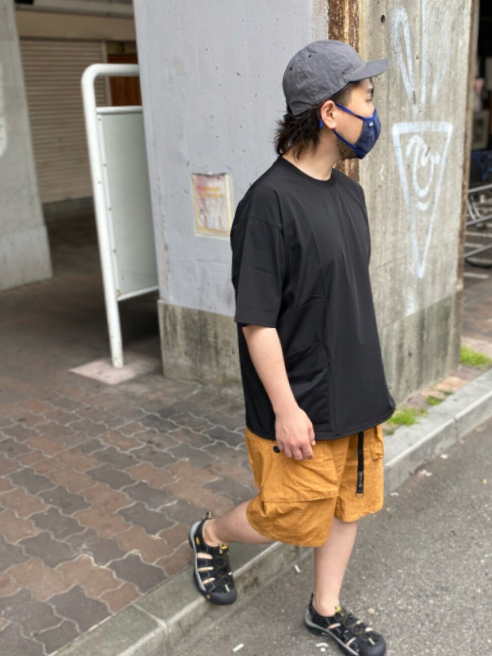 ブラック系のTシャツ/カットソー、グリーン系のパンツ、ブラック系のサンダルを着用したメンズの夏コーディネートの3枚目の写真