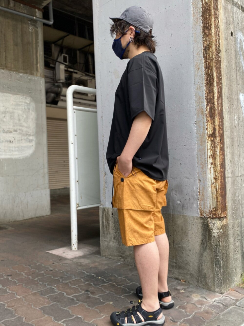 ブラック系のTシャツ/カットソー、グリーン系のパンツ、ブラック系のサンダルを着用したメンズの夏コーディネートの2枚目の写真