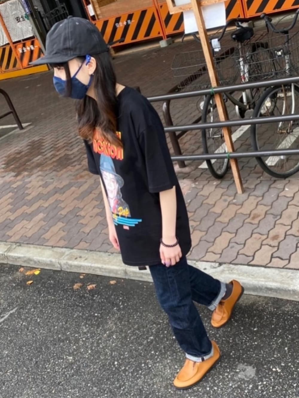ブラック系のTシャツ/カットソー、ブルー系のデニムパンツ、ブラウン系のスニーカーを着用したレディースの夏コーディネートの2枚目の写真