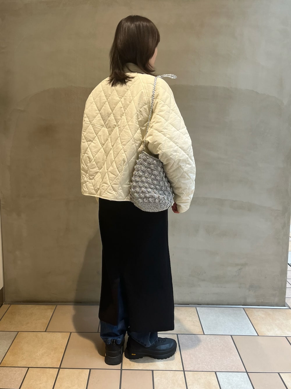 ブラック系のサロペット/オーバーオール、ブルー系のスウェット、ホワイト系のダウンジャケット/コートを着用したレディースの冬コーディネートの2枚目の写真