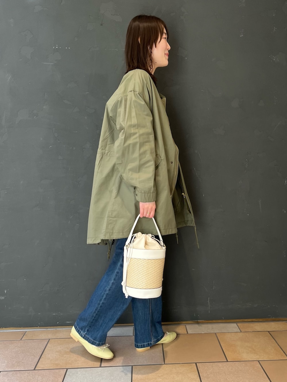 ブルー系のデニムパンツ、イエロー系のバレエシューズを着用したレディースの春コーディネートの4枚目の写真