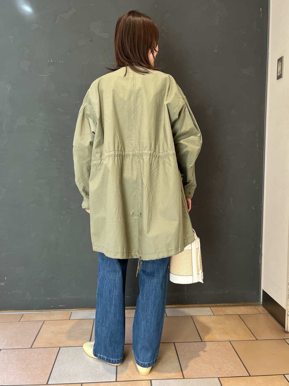 ブルー系のデニムパンツ、イエロー系のバレエシューズを着用したレディースの春コーディネートの3枚目の写真