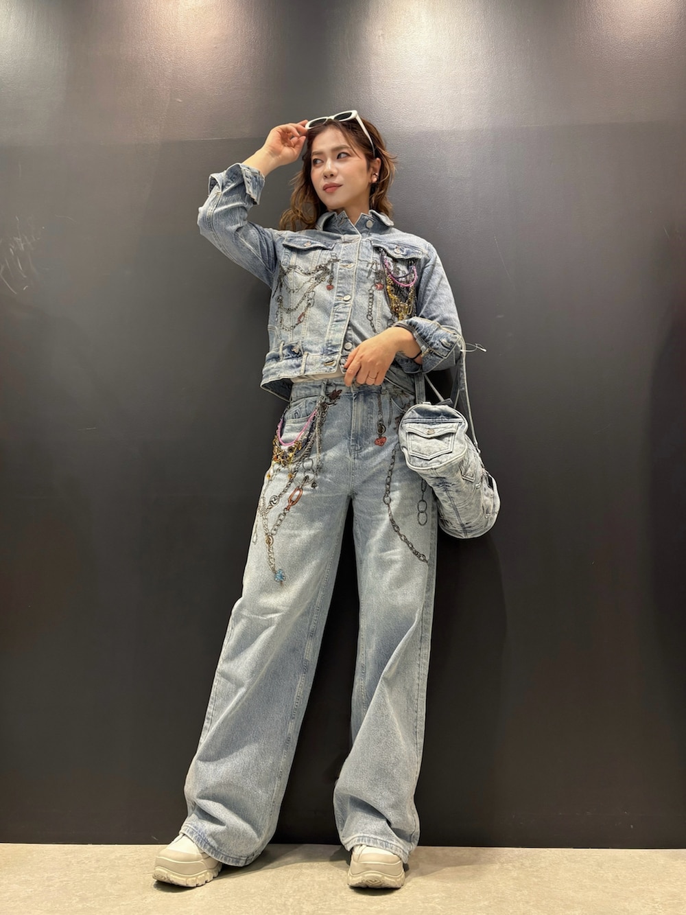 ブルー系のデニムジャケット、ブルー系のデニムパンツ、ブルー系のハンドバッグを着用したレディースの春コーディネートの3枚目の写真