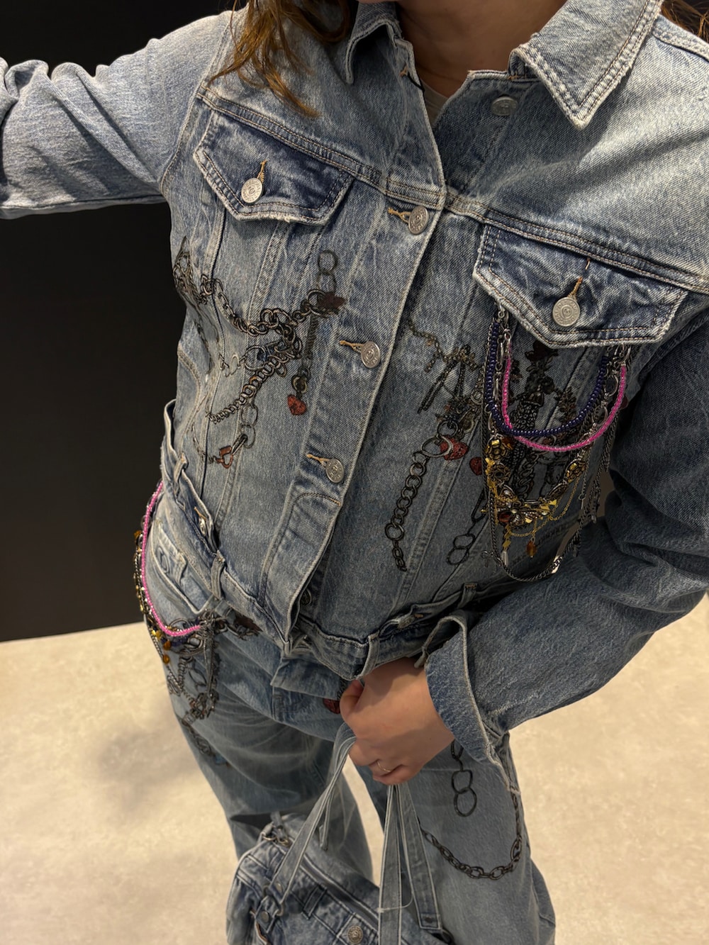 ブルー系のデニムジャケット、ブルー系のデニムパンツ、ブルー系のハンドバッグを着用したレディースの春コーディネートの2枚目の写真