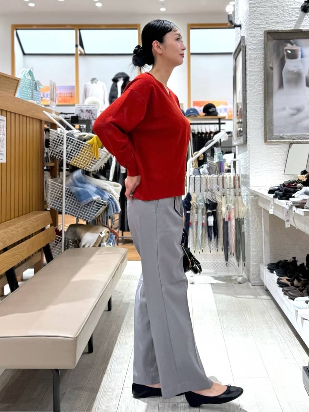 ブラック系のバレエシューズ、ブルー系のダウンジャケット/コート、レッド系のニット/セーターを着用したレディースの秋コーディネートの5枚目の写真