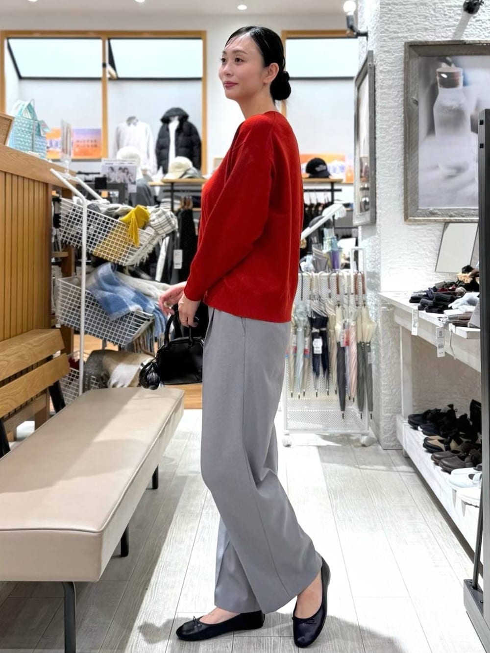 ブラック系のバレエシューズ、ブルー系のダウンジャケット/コート、レッド系のニット/セーターを着用したレディースの秋コーディネートの9枚目の写真