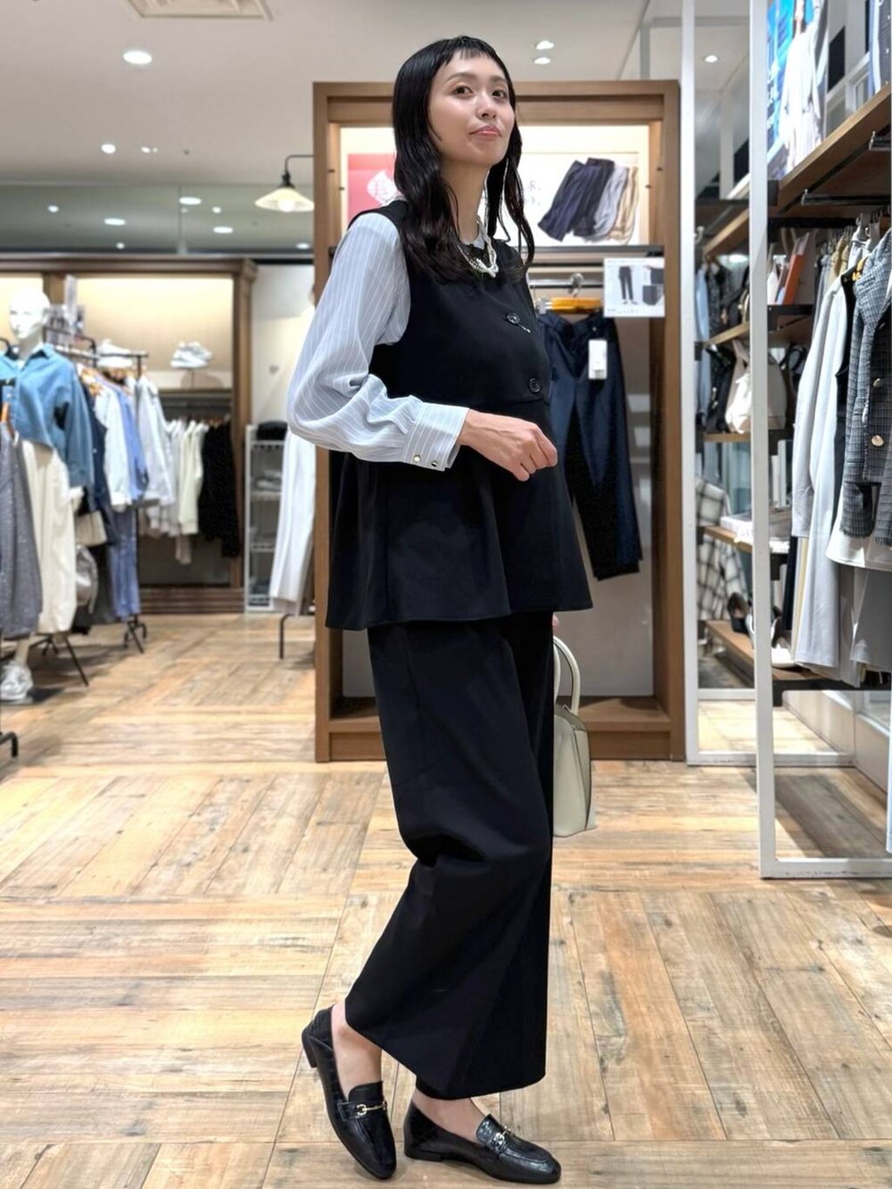 ブラック系のローファー、ブラック系のその他パンツ、ブルー系のシャツ/ブラウスを着用したレディースの春コーディネートの2枚目の写真