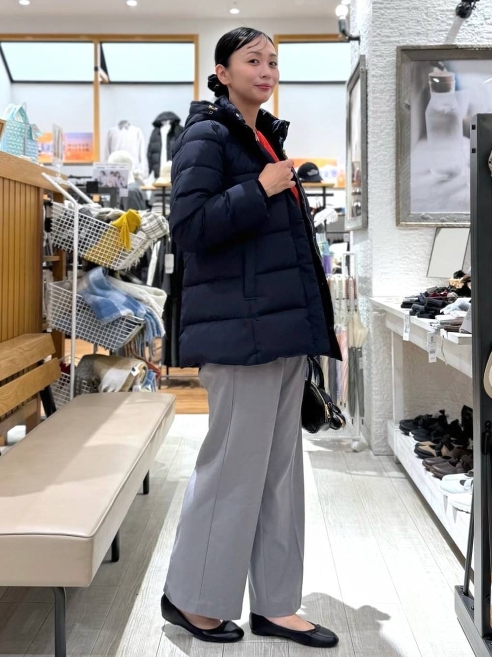 ブラック系のバレエシューズ、ブルー系のダウンジャケット/コート、レッド系のニット/セーターを着用したレディースの秋コーディネートの4枚目の写真