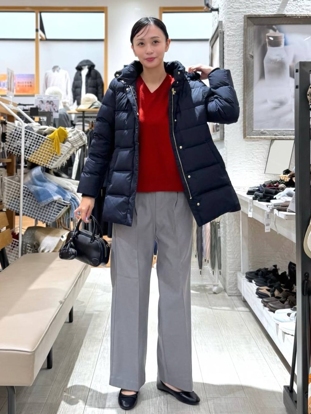 ブラック系のバレエシューズ、ブルー系のダウンジャケット/コート、レッド系のニット/セーターを着用したレディースの秋コーディネートの2枚目の写真