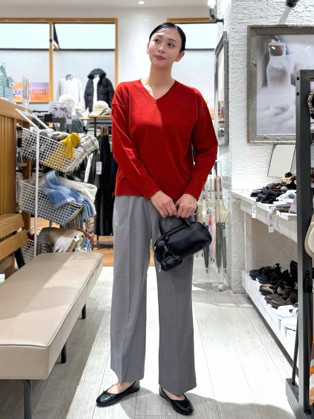 ブラック系のバレエシューズ、ブルー系のダウンジャケット/コート、レッド系のニット/セーターを着用したレディースの秋コーディネートの3枚目の写真