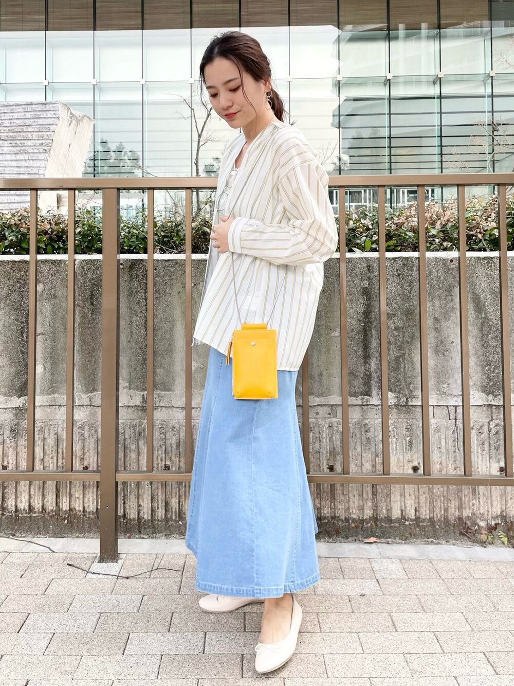 イエロー系のシャツ/ブラウス、ベージュ系のその他シューズ、ブルー系のスカートを着用したレディースの春コーディネートの2枚目の写真