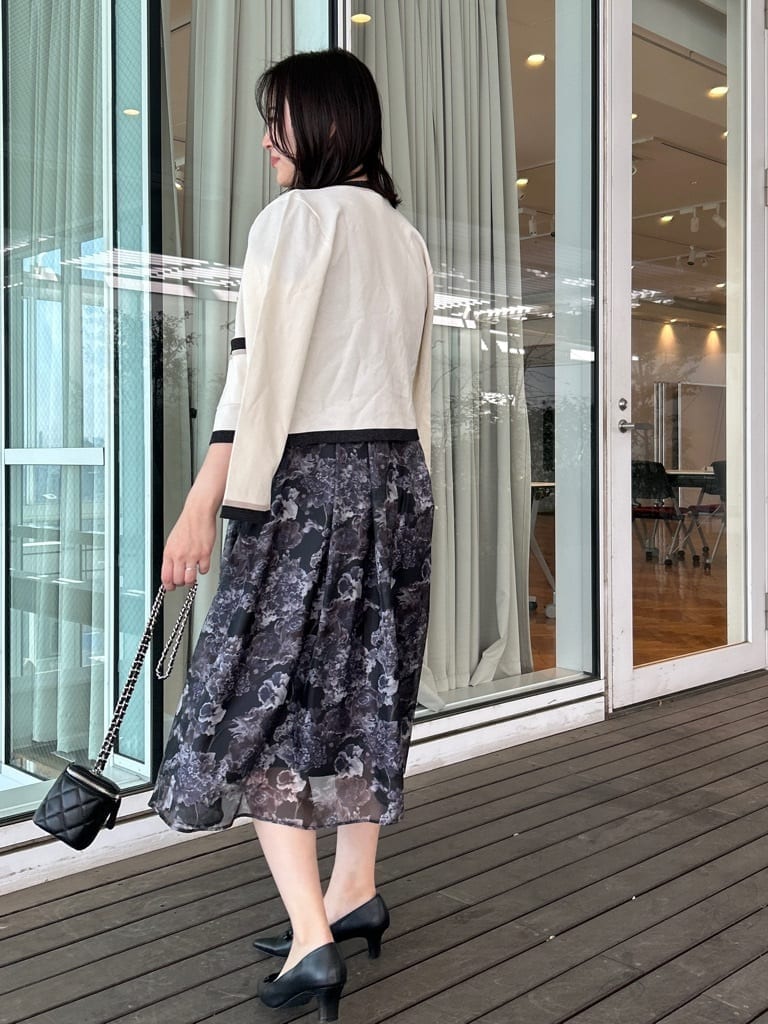 ブラック系のパンプス、ブラック系のシャツ/ブラウス、ホワイト系のカーディガン/ボレロを着用したレディースの春コーディネートの3枚目の写真