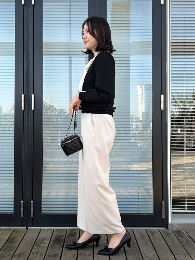 ブラック系のニット/セーター、ホワイト系のその他パンツを着用したレディースの春コーディネートの2枚目の写真