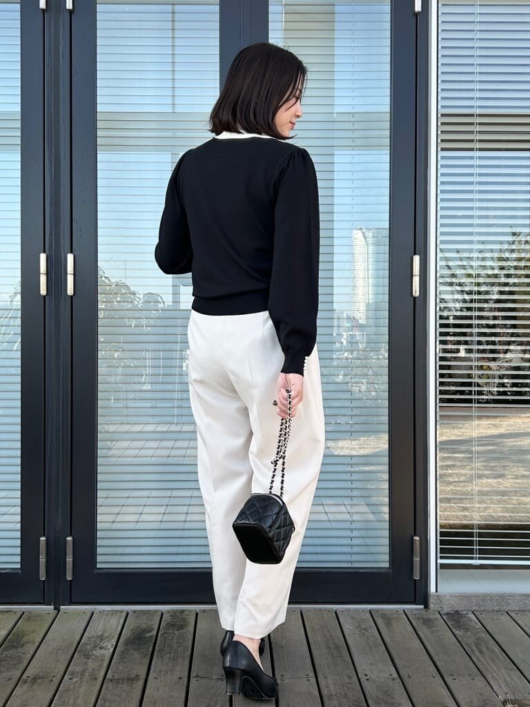 ブラック系のニット/セーター、ホワイト系のその他パンツを着用したレディースの春コーディネートの3枚目の写真