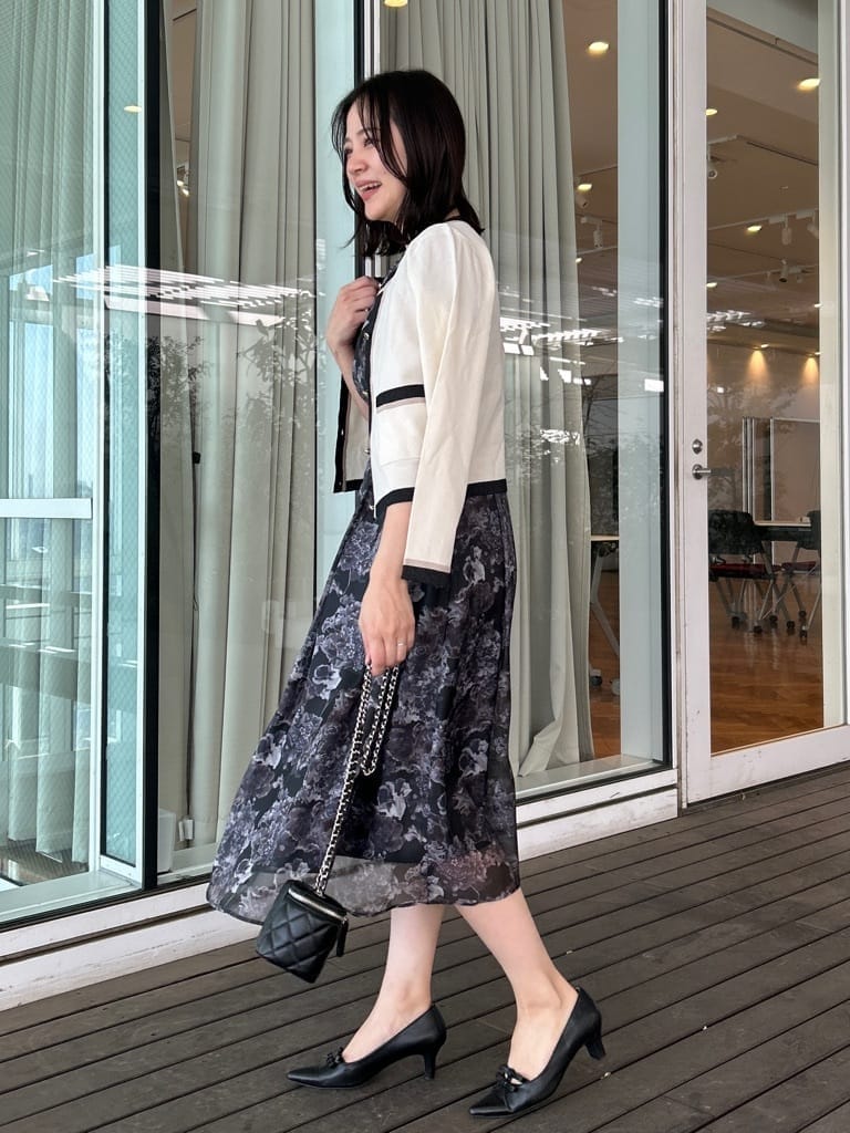 ブラック系のパンプス、ブラック系のシャツ/ブラウス、ホワイト系のカーディガン/ボレロを着用したレディースの春コーディネートの2枚目の写真